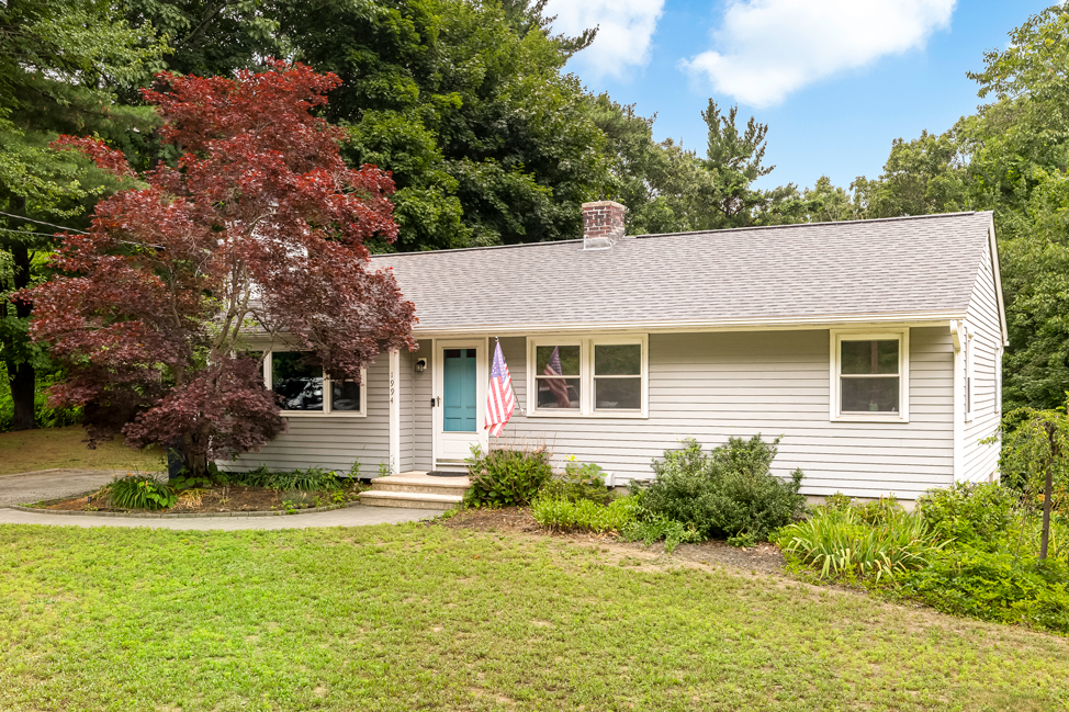 Front exterior of a move-in ready three-bedroom ranch home in Holden, Massachusetts with mature landscaping, new roof, and attached driveway.